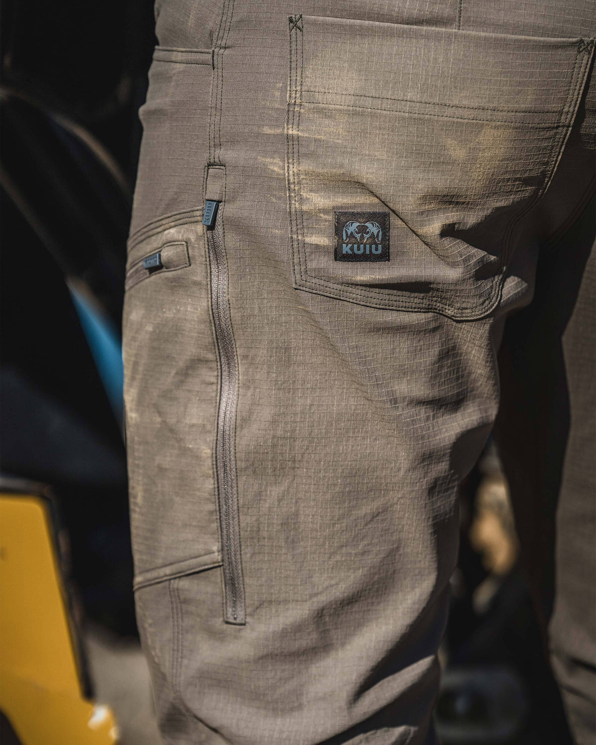 Close-up of side zippered thigh pockets and left back pocket on the Motive Workgrade Pant in Rodeo Brown.